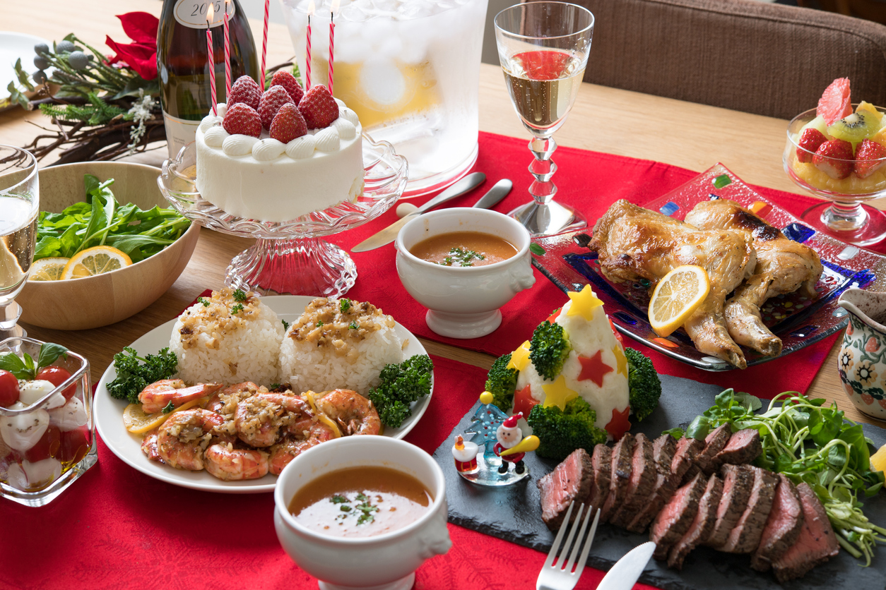 masa bogata de craciun cu preparate variate, tort, si o sticla de sampanie