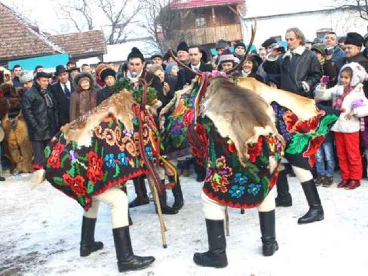 barbati in costume populare care merg cu capra