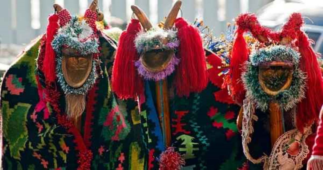 3 oameni costumati in capra, cu straie populare