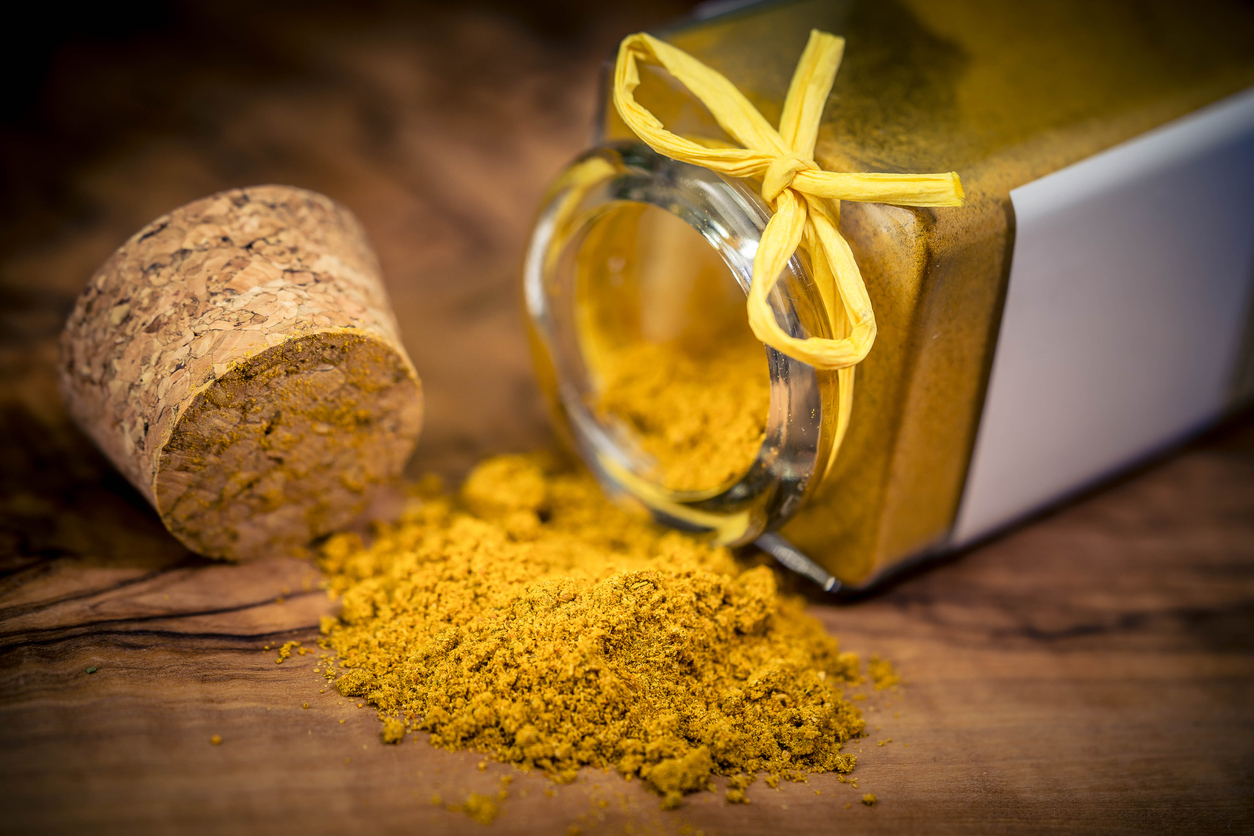 borcan cu pudra de ras al honut rasturnat pe o masa de lemn