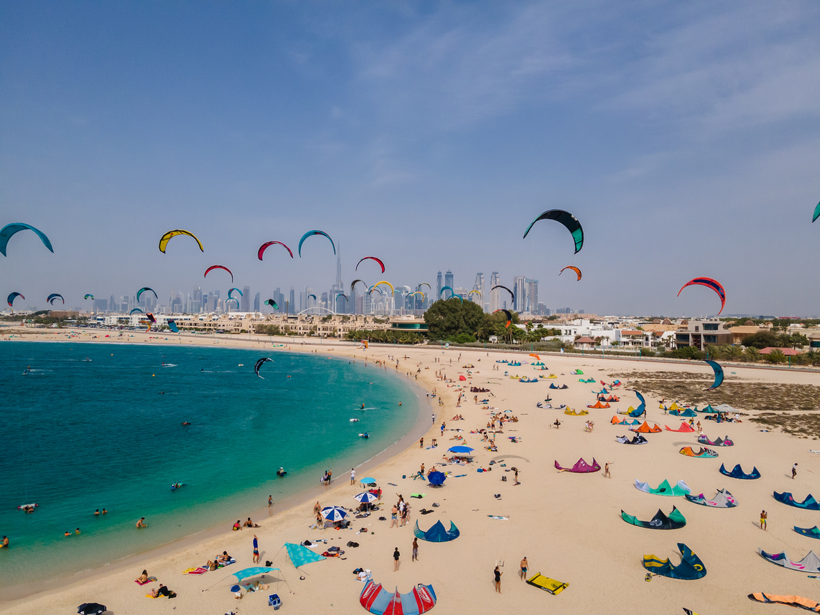 O lovitură aeriană de Kite Beach din Dubai umplut cu surferi zmeu și zmee lor colorate care zboară în aer