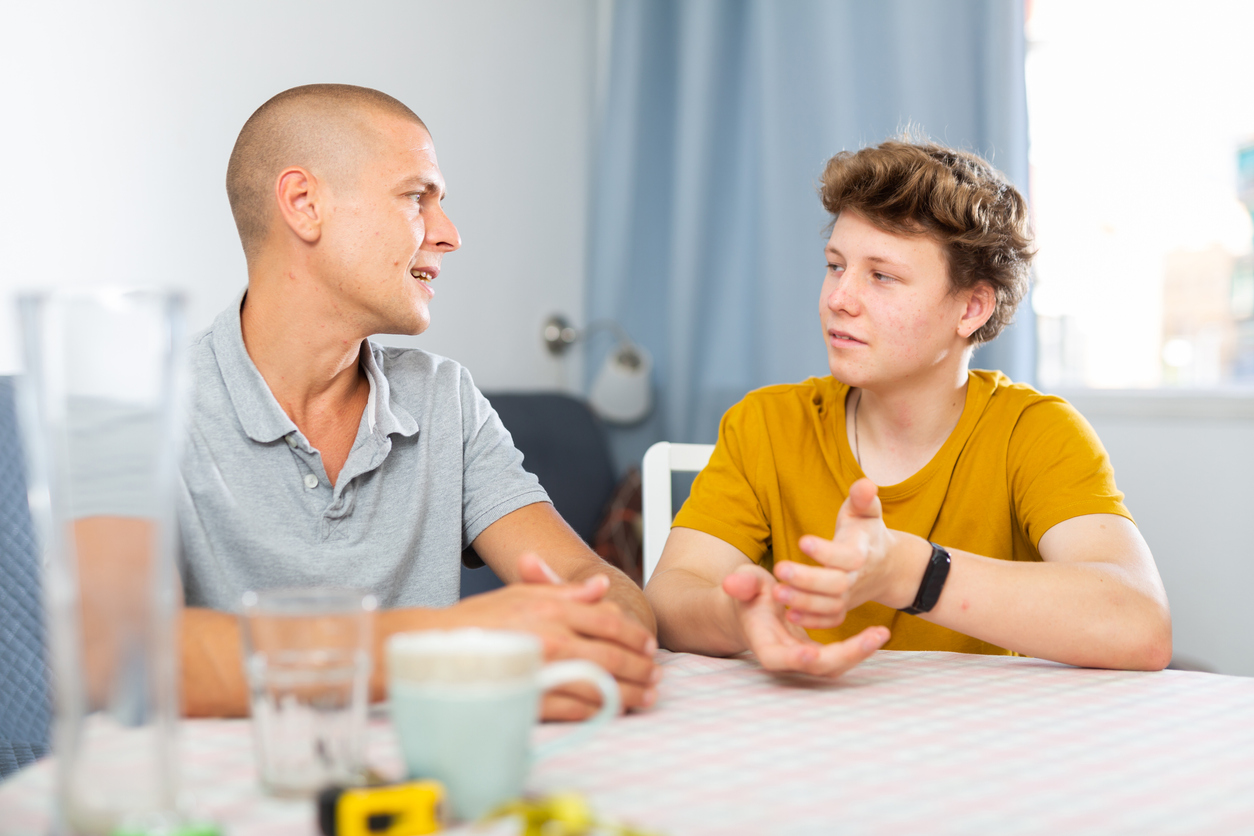 tata si copilul adolescent poarta o discutie la masa