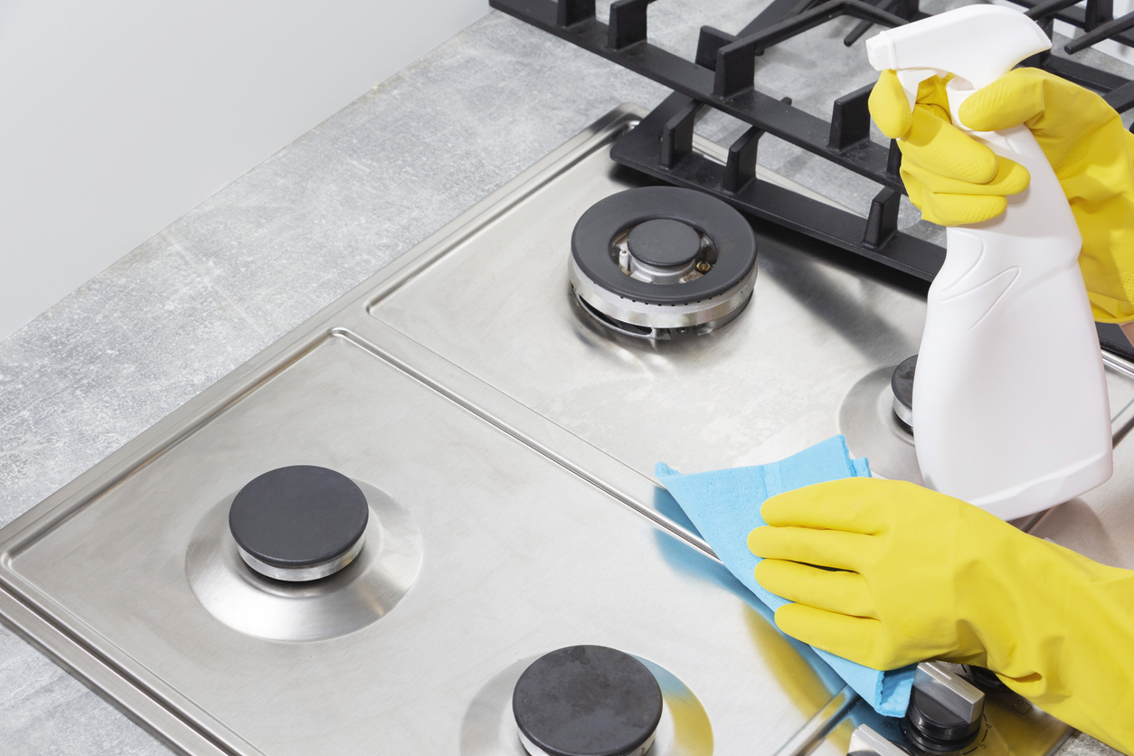 Curățarea unei sobe pe gaz cu ustensile de bucătărie,