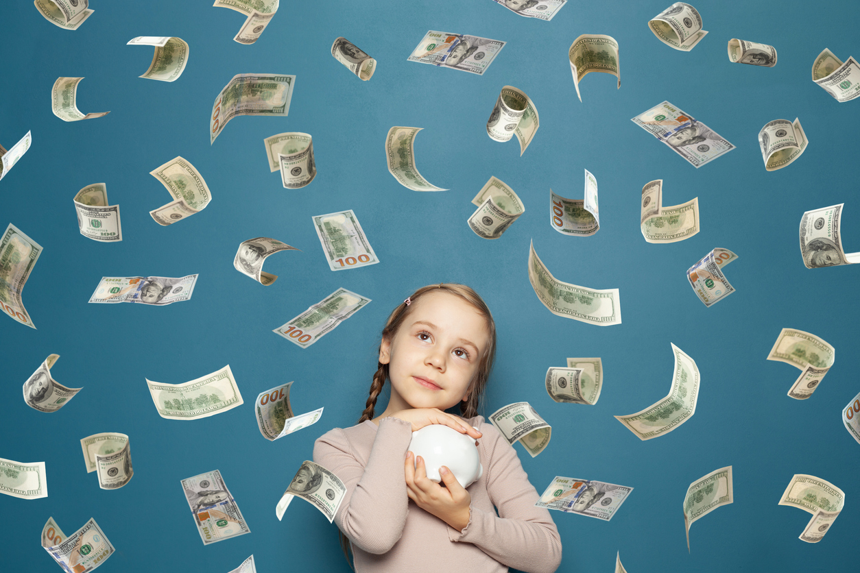 fetita c tine o pusculita in brate si o ploaie de bani