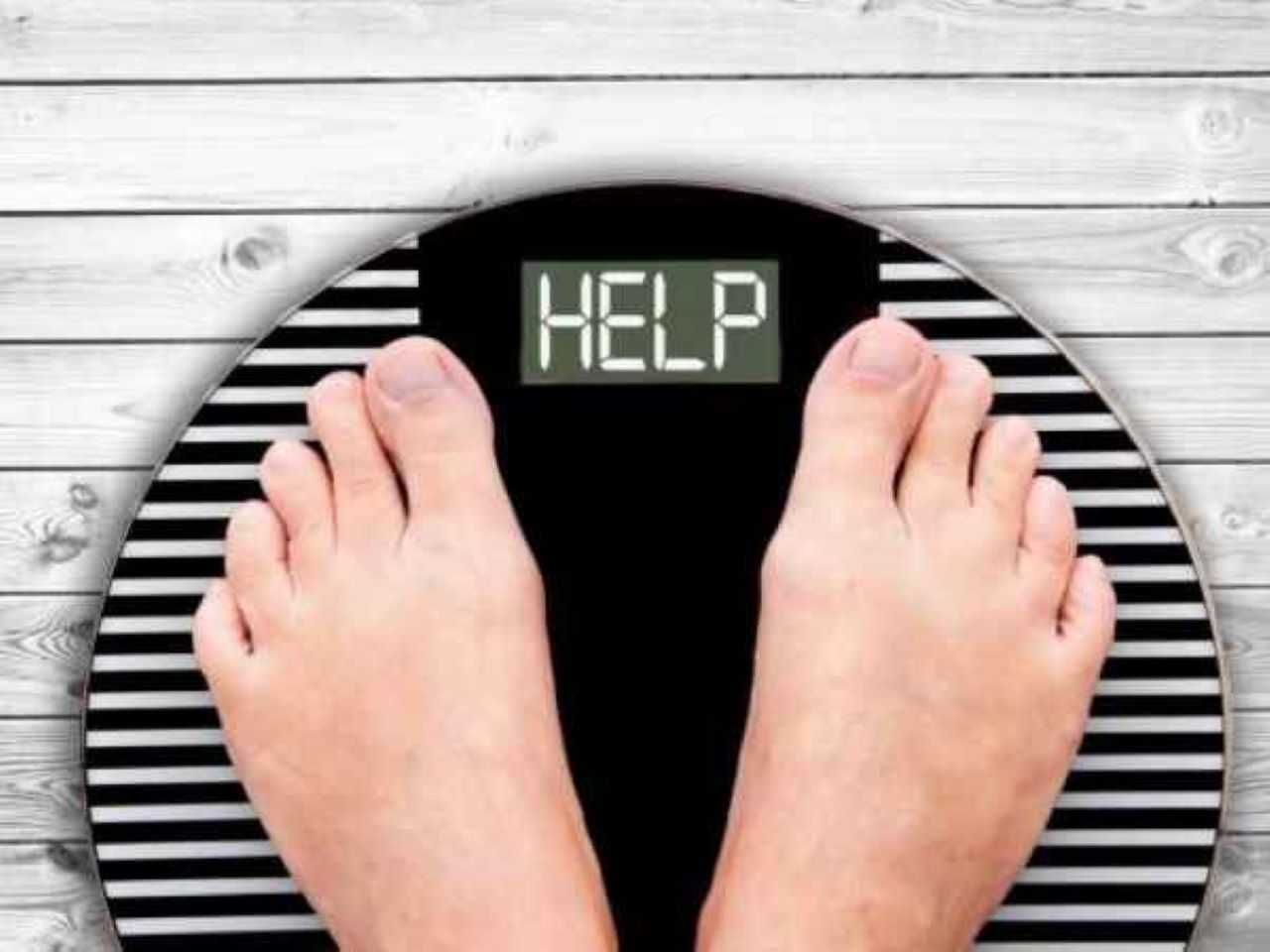 femeie care sta pe un cantar ce afiseaza mesajul help