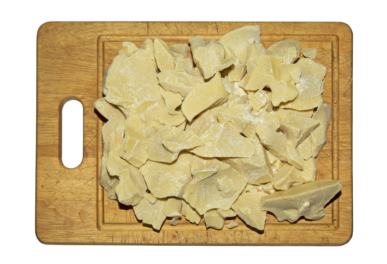 bucati de unt de cacao pe un tocator de lemn