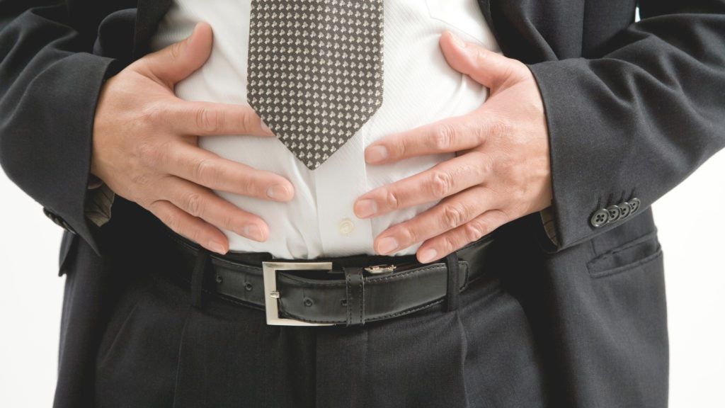 Barbat in costum care sufera de balonare