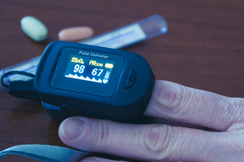 femeie care-si masoara saturatia de O cu ajutorul pulsoximetrului