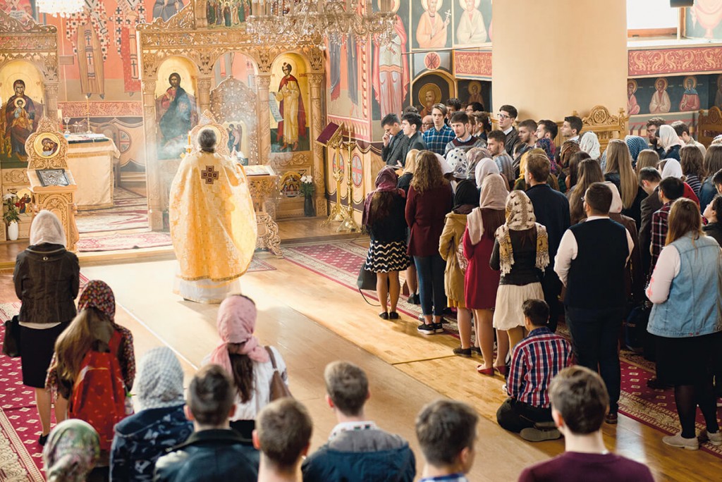 Oameni in biserica participand la slujba