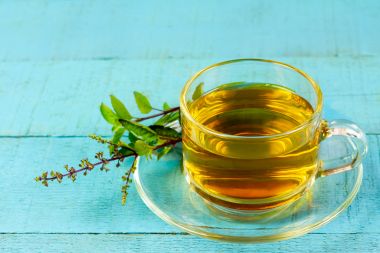 cana cu ceai de busuioc si o crenguta de busuioc