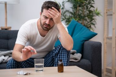 Bărbatul care simte dureri de cap rău din cauza mahmurelii