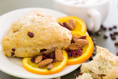 farfurie cu un fursec, felii de portocale si migdale