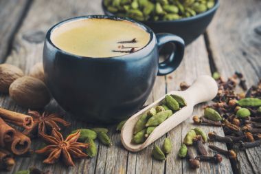 Ceașcă de ceai de masala ayurvedic sănătos sau cafea cu condimente aromatice.