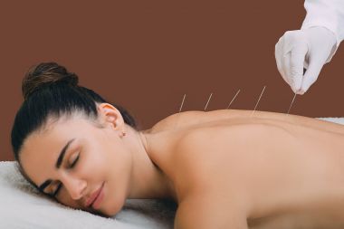 Femeia se relaxeaza de la procedura de acupunctura.