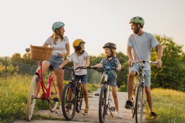 Familie fericită cu bicicleta împreună în mediul rural