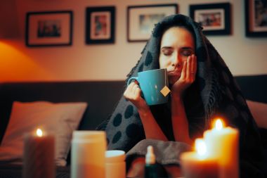 Femeie tristă și nefericită care își tratează simptomele răcelii cu ceai