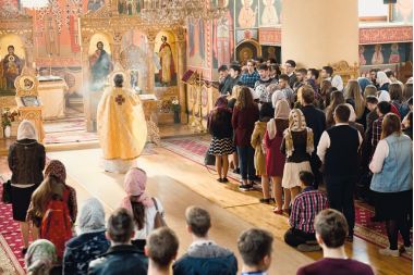 Oameni in biserica participand la slujba