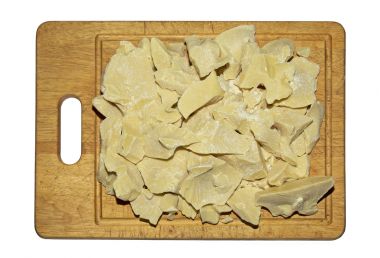 bucati de unt de cacao pe un tocator de lemn