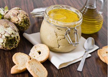 borcan cu crema de anghinare, o anginare cruda si o carafa de ueli de masline