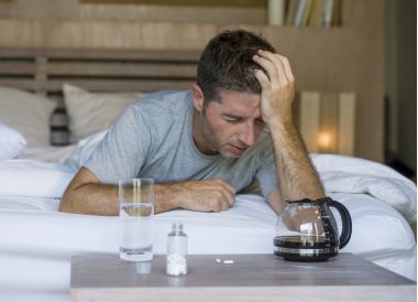 tânăr epuizat și irosit om trezirea suferind dureri de cap și mahmureala după ce a băut alcool la petrecere de noapte