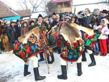 barbati in costume populare care merg cu capra